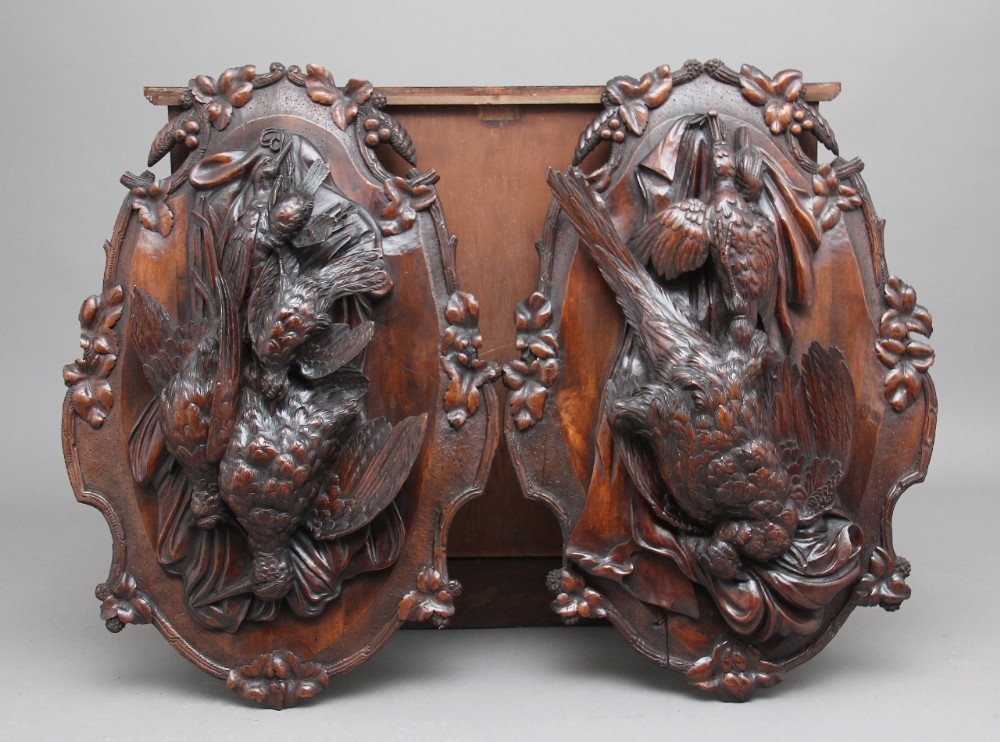 A pair of 19th Century walnut black forest wall plaques