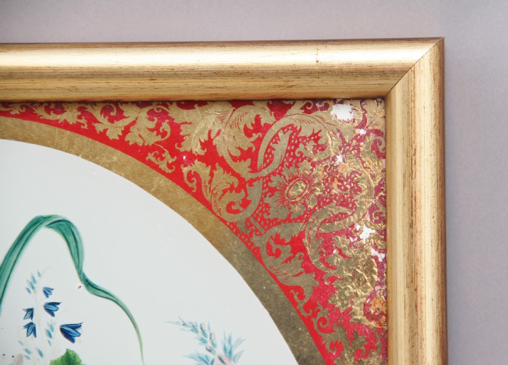 A pair of early 19th-century framed botanical paintings depicting colourful floral bouquets within oval apertures surrounded by red and gold patterned borders. View V