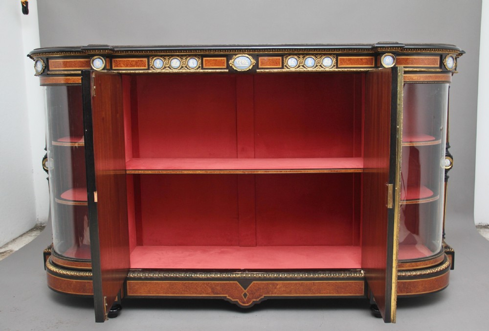 A 19th-century ebonised and amboyna wood credenza featuring central doors with oval pietre dure panels, porcelain medallion inserts, gilt bronze mounts, and curved glass side compartments. View III