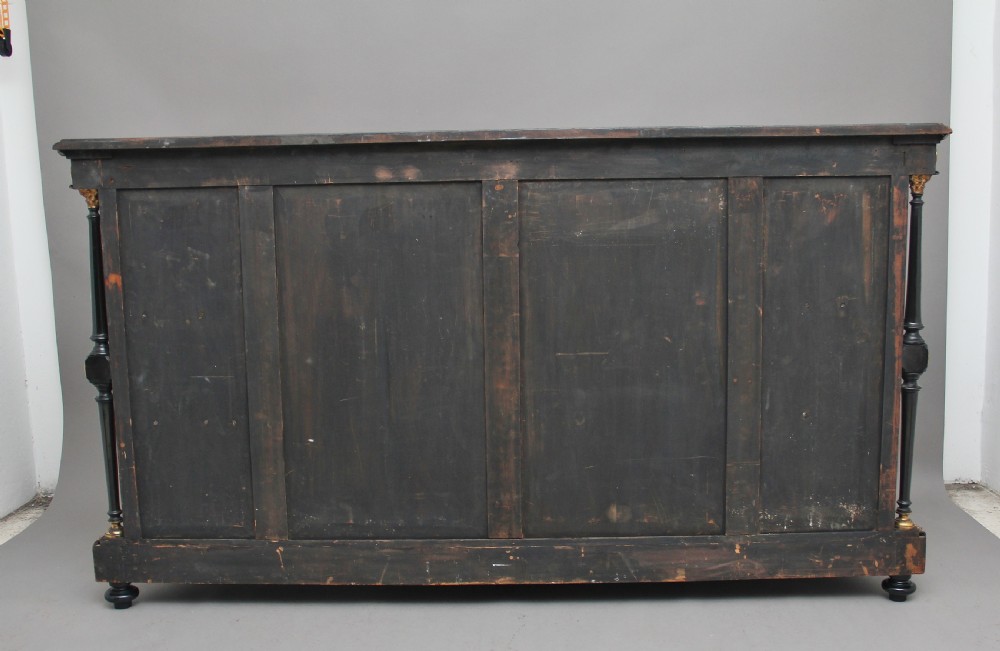A 19th-century ebonised and amboyna wood credenza featuring central doors with oval pietre dure panels, porcelain medallion inserts, gilt bronze mounts, and curved glass side compartments. View VII