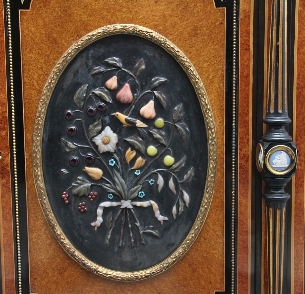 A 19th-century ebonised and amboyna wood credenza featuring central doors with oval pietre dure panels, porcelain medallion inserts, gilt bronze mounts, and curved glass side compartments. View XIII