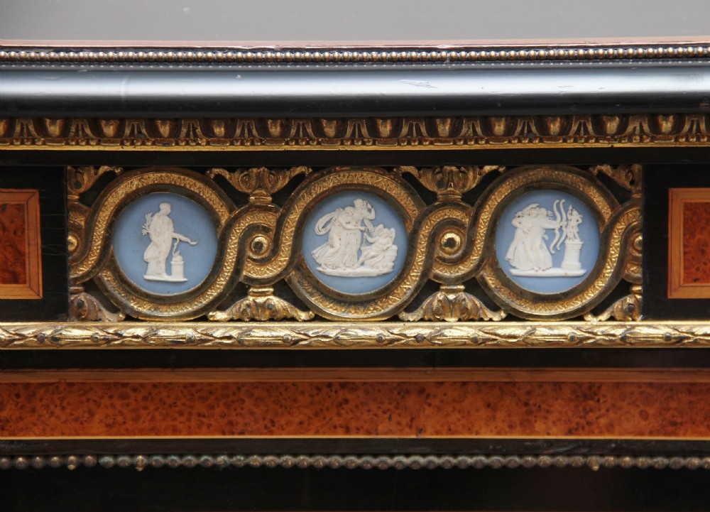 A 19th-century ebonised and amboyna wood credenza featuring central doors with oval pietre dure panels, porcelain medallion inserts, gilt bronze mounts, and curved glass side compartments. View XVI