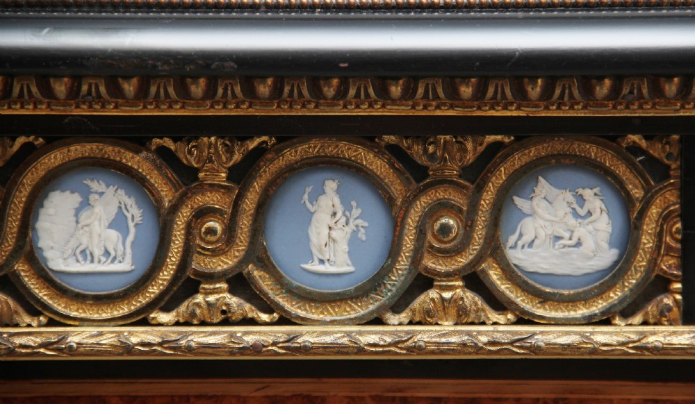 A 19th-century ebonised and amboyna wood credenza featuring central doors with oval pietre dure panels, porcelain medallion inserts, gilt bronze mounts, and curved glass side compartments. View XVIII