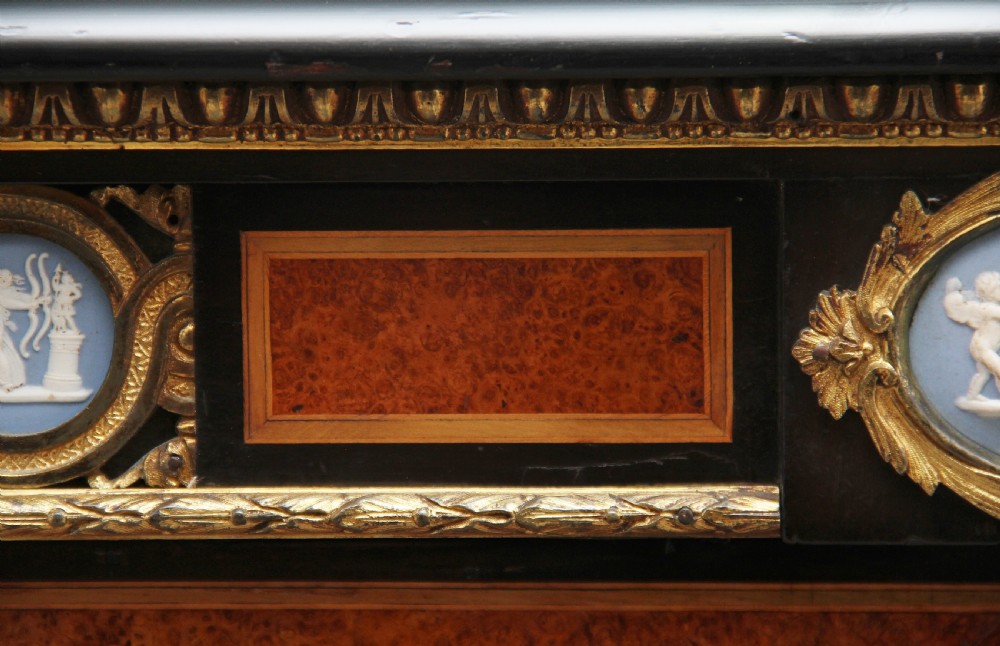 A 19th-century ebonised and amboyna wood credenza featuring central doors with oval pietre dure panels, porcelain medallion inserts, gilt bronze mounts, and curved glass side compartments. View XXVI