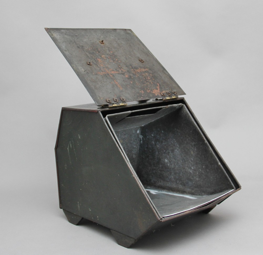 A nineteenth-century black metal coal box featuring a slanted drop front decorated with hand-painted pink flowers, brass strap hinges, a brass knob, and a top carrying handle. View II