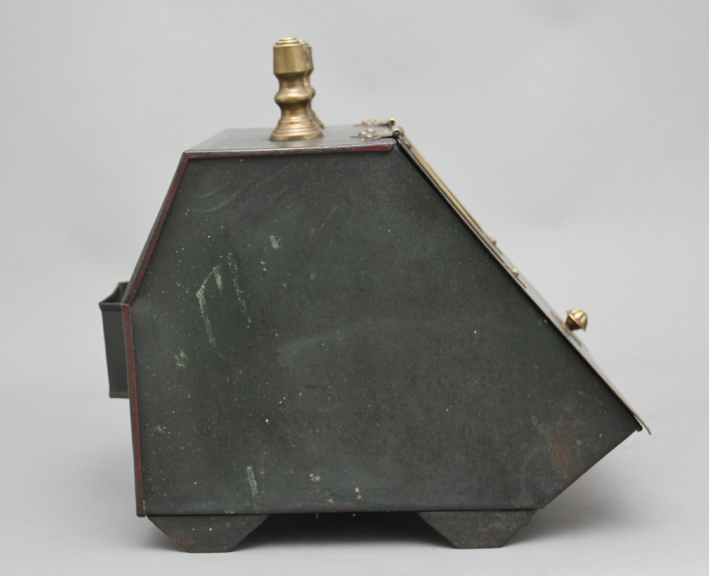 A nineteenth-century black metal coal box featuring a slanted drop front decorated with hand-painted pink flowers, brass strap hinges, a brass knob, and a top carrying handle. View VII