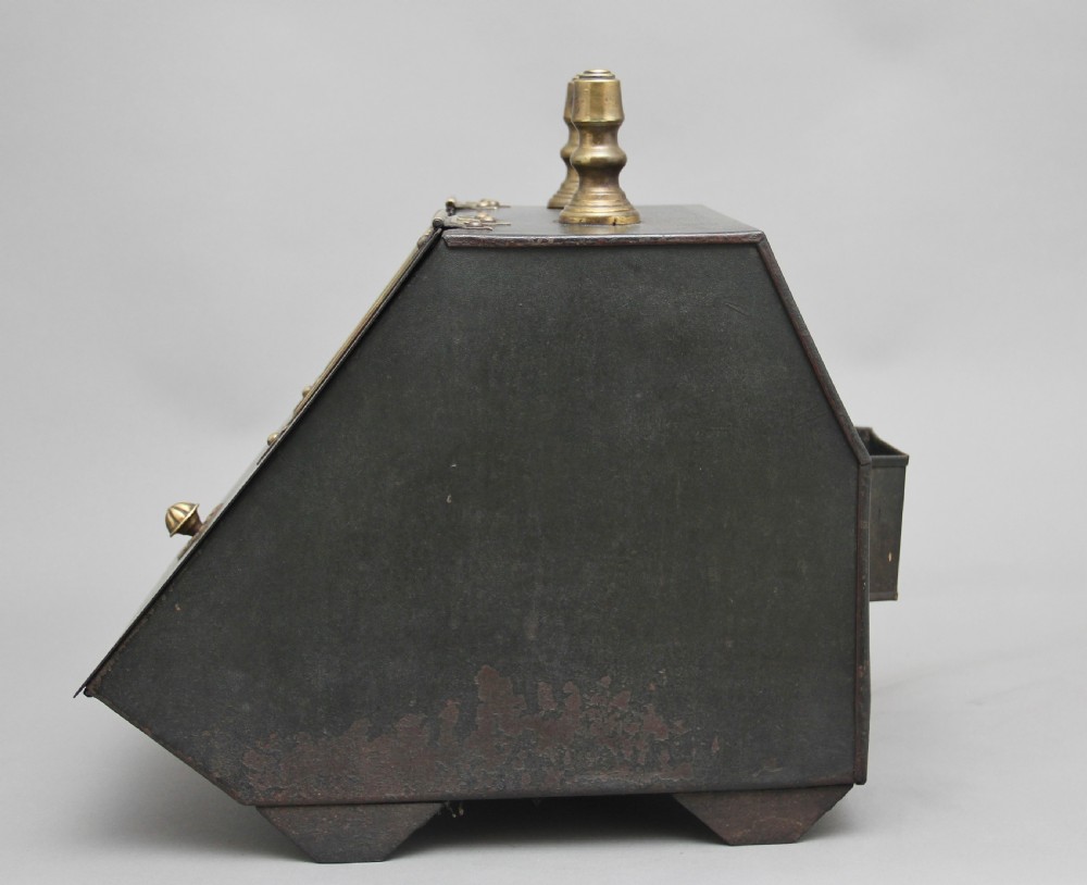 A nineteenth-century black metal coal box featuring a slanted drop front decorated with hand-painted pink flowers, brass strap hinges, a brass knob, and a top carrying handle. View IX