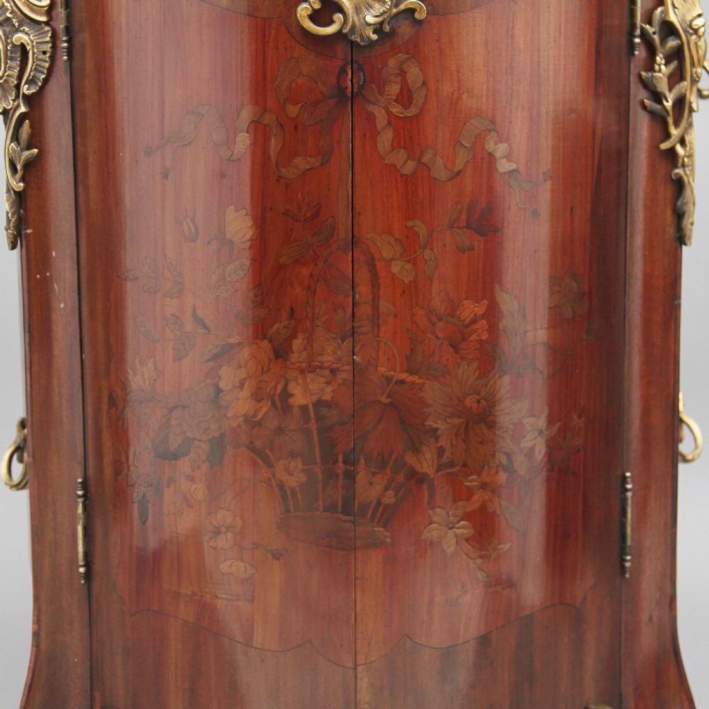 An early 19th-century French marquetry cabinet with a curved front, marble top, detailed wood inlay depicting a scenic landscape, and ornamental brass mounts. View VIII