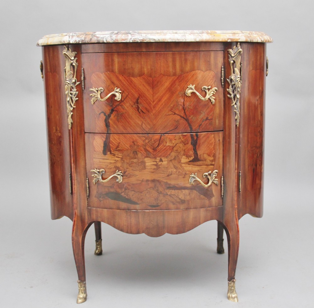 An early 19th-century French marquetry cabinet with a curved front, marble top, detailed wood inlay depicting a scenic landscape, and ornamental brass mounts. View XI
