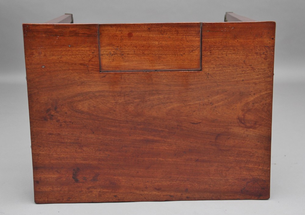 An early nineteenth-century mahogany writing table featuring square tapered legs on brass castors, a single drawer with turned wooden handles, and an adjustable reading slope set into the top. View XI