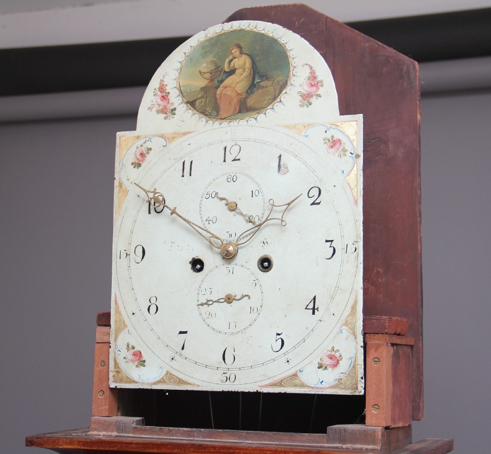 A 19th-century mahogany longcase clock featuring a swan-neck pediment hood, an arched painted clock dial, a flame mahogany trunk door with marquetry inlay, and a plinth base. View III