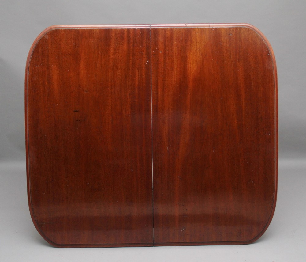 A 19th-century mahogany extending dining table with rounded corners, a polished rectangular top, turned legs, and brass castors. View V
