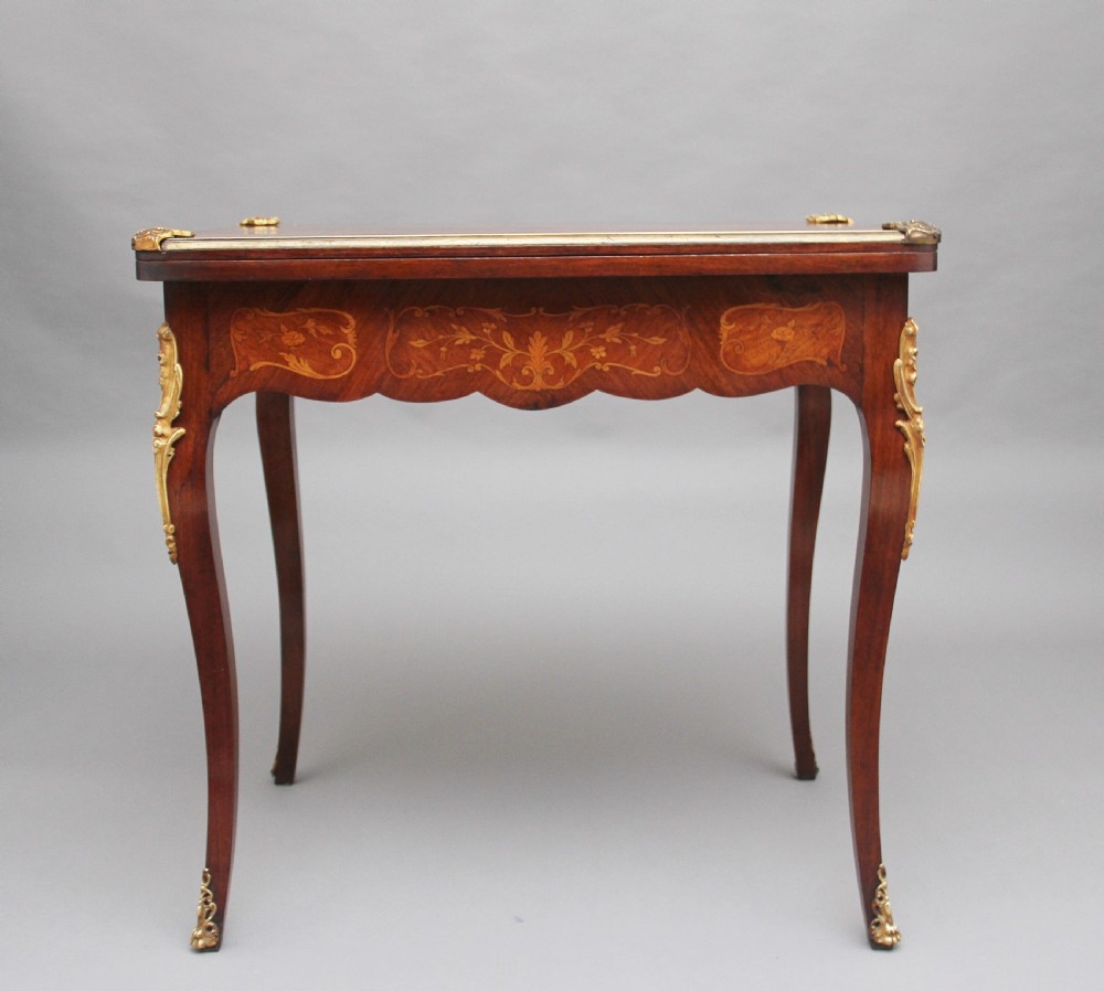 A 19th-century French Rococo revival kingwood fold-over card table with floral marquetry inlay, cabriole legs, and ornate gilt ormolu mounts. View II