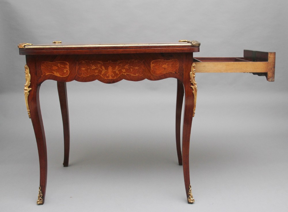 A 19th-century French Rococo revival kingwood fold-over card table with floral marquetry inlay, cabriole legs, and ornate gilt ormolu mounts. View III