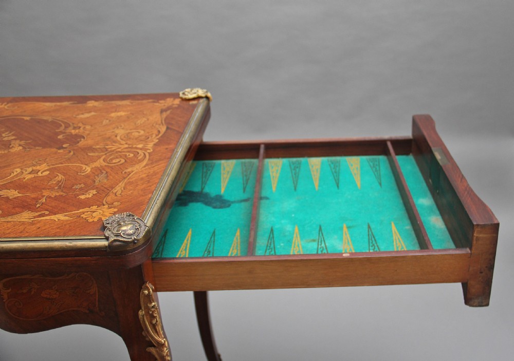 A 19th-century French Rococo revival kingwood fold-over card table with floral marquetry inlay, cabriole legs, and ornate gilt ormolu mounts. View IV