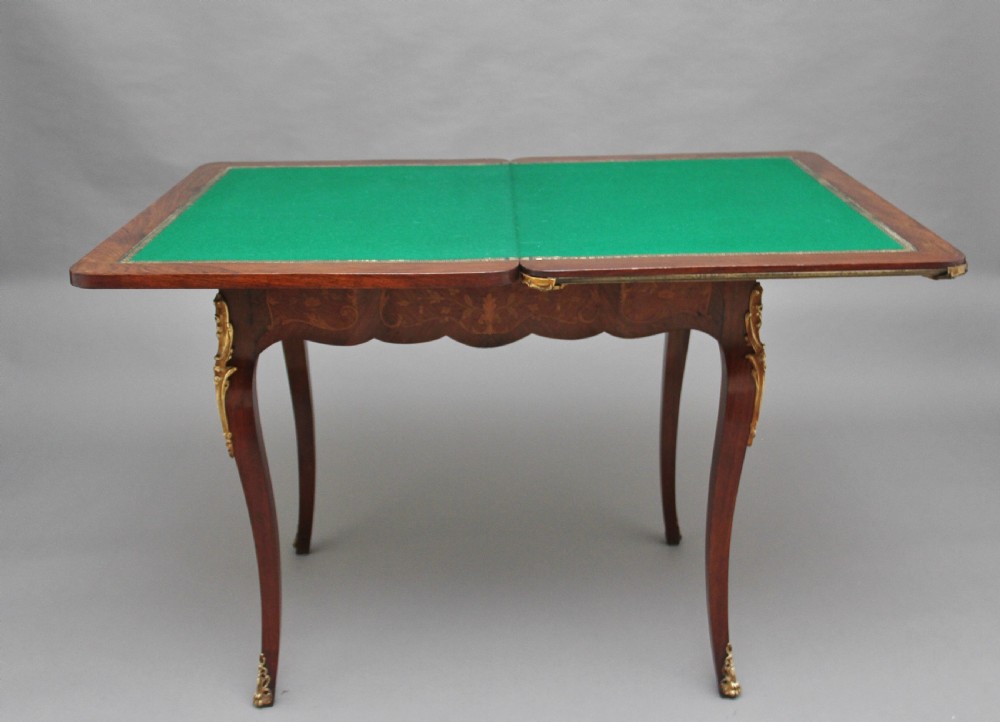 A 19th-century French Rococo revival kingwood fold-over card table with floral marquetry inlay, cabriole legs, and ornate gilt ormolu mounts. View VI