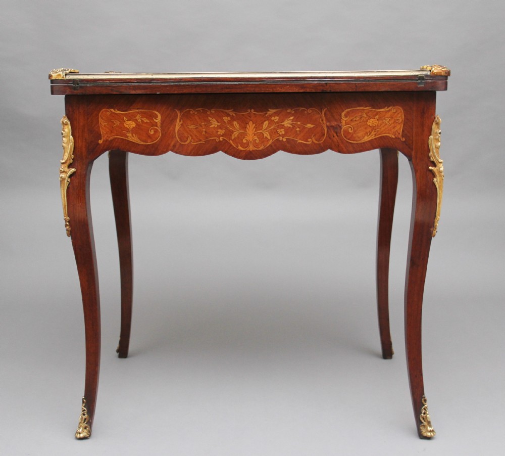 A 19th-century French Rococo revival kingwood fold-over card table with floral marquetry inlay, cabriole legs, and ornate gilt ormolu mounts. View XI