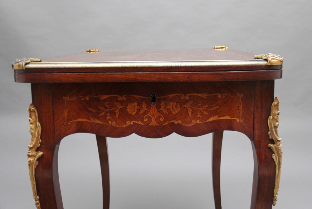 A 19th-century French Rococo revival kingwood fold-over card table with floral marquetry inlay, cabriole legs, and ornate gilt ormolu mounts. View XIII