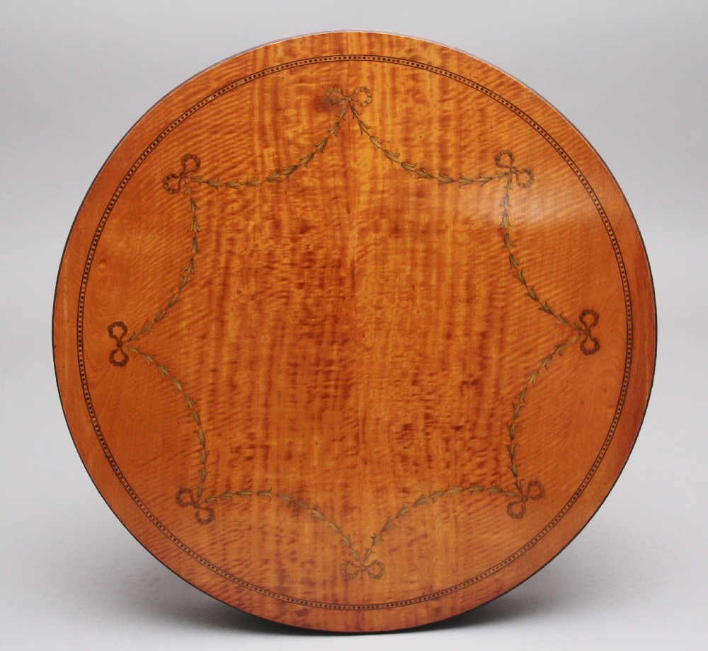 An oval 19th-century satinwood occasional table featuring floral marquetry along the apron, tapered square legs, and a small circular undertier. View II