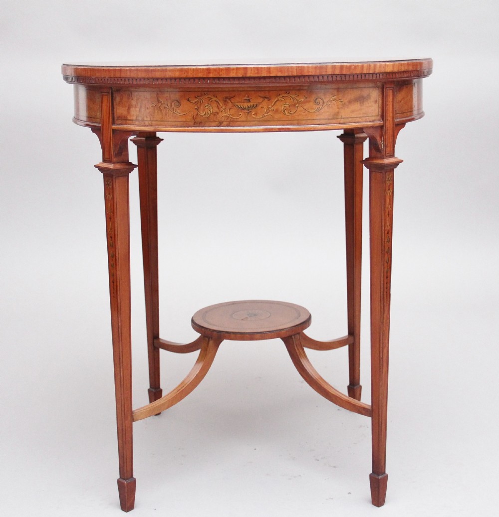 An oval 19th-century satinwood occasional table featuring floral marquetry along the apron, tapered square legs, and a small circular undertier. View IV
