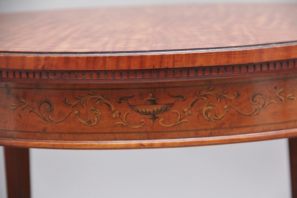 An oval 19th-century satinwood occasional table featuring floral marquetry along the apron, tapered square legs, and a small circular undertier. View VII