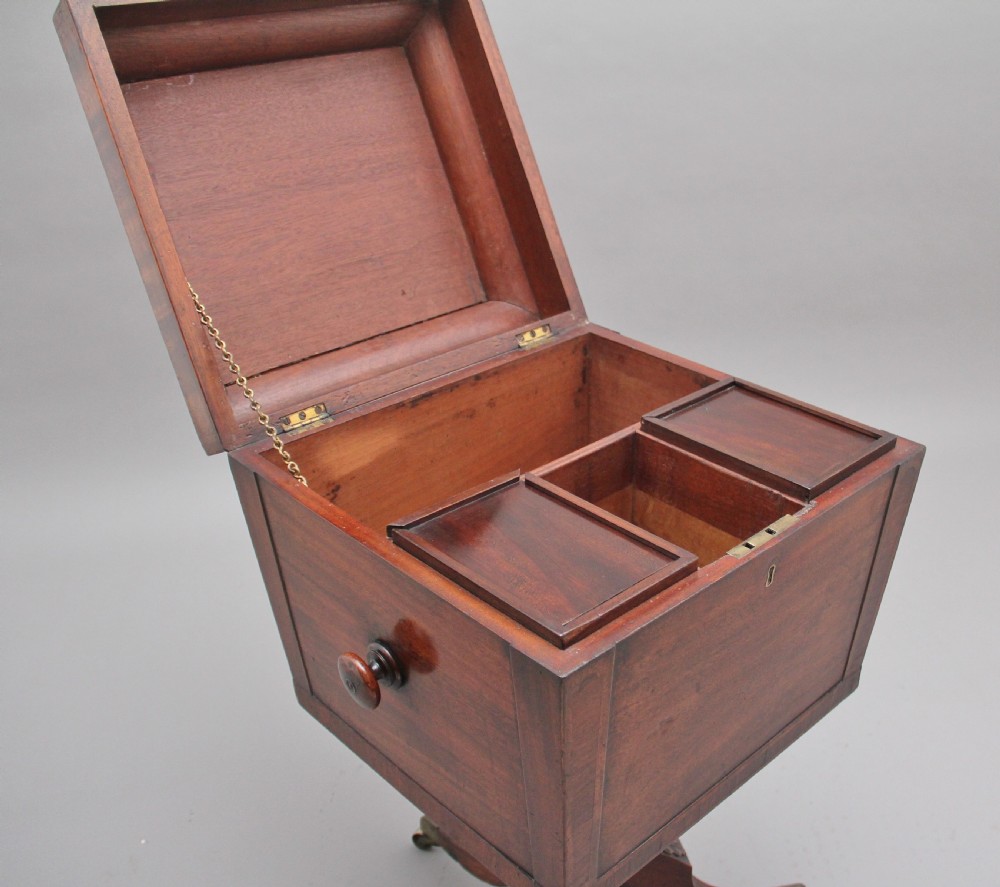 An early 19th-century Regency mahogany teapoy with a hinged tapered box mounted on a turned pedestal and reeded tripod legs with brass castors. View III