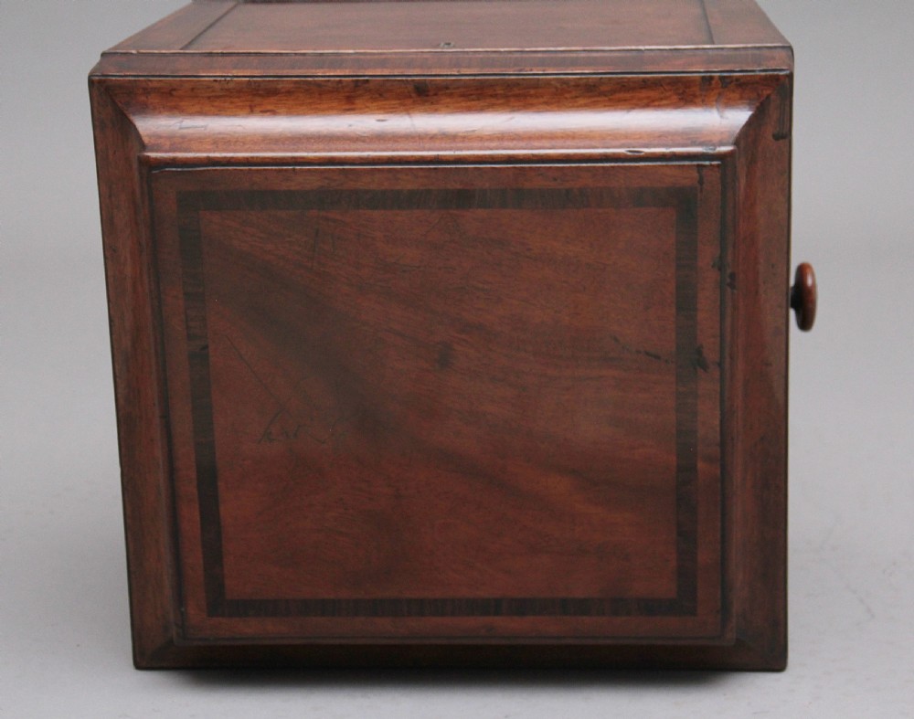 An early 19th-century Regency mahogany teapoy with a hinged tapered box mounted on a turned pedestal and reeded tripod legs with brass castors. View XI