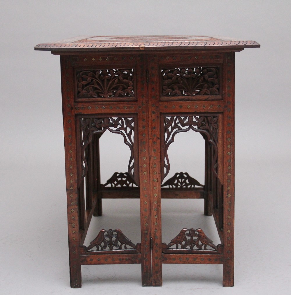 A 19th-century dark hardwood Indian occasional table featuring intricately carved floral fretwork panels, cusped arches, and a geometric bone-inlaid tabletop. View III
