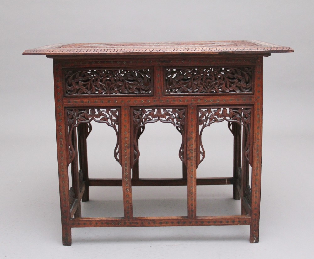 A 19th-century dark hardwood Indian occasional table featuring intricately carved floral fretwork panels, cusped arches, and a geometric bone-inlaid tabletop. View IV