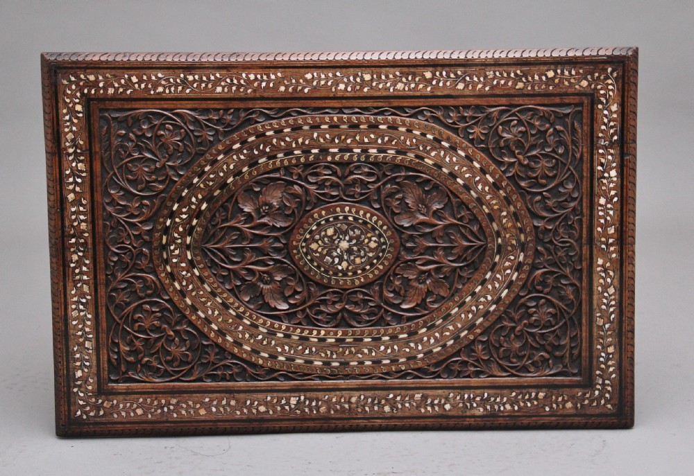 A 19th-century dark hardwood Indian occasional table featuring intricately carved floral fretwork panels, cusped arches, and a geometric bone-inlaid tabletop. View VI