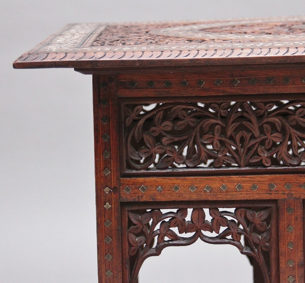 A 19th-century dark hardwood Indian occasional table featuring intricately carved floral fretwork panels, cusped arches, and a geometric bone-inlaid tabletop. View VIII