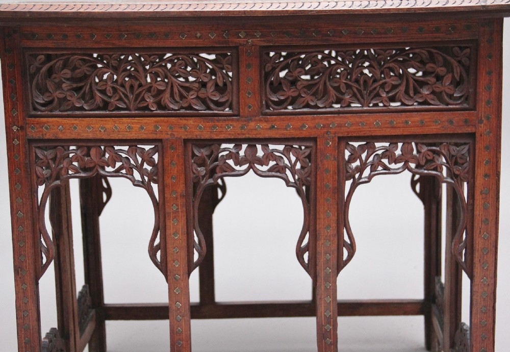 A 19th-century dark hardwood Indian occasional table featuring intricately carved floral fretwork panels, cusped arches, and a geometric bone-inlaid tabletop. View IX