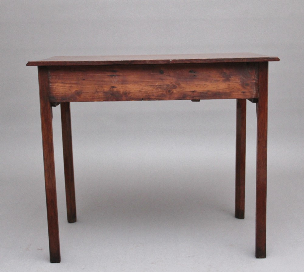 An early 19th-century oak lowboy side table featuring two drawers with brass handles, a shaped lower apron, and four straight legs. View VIII
