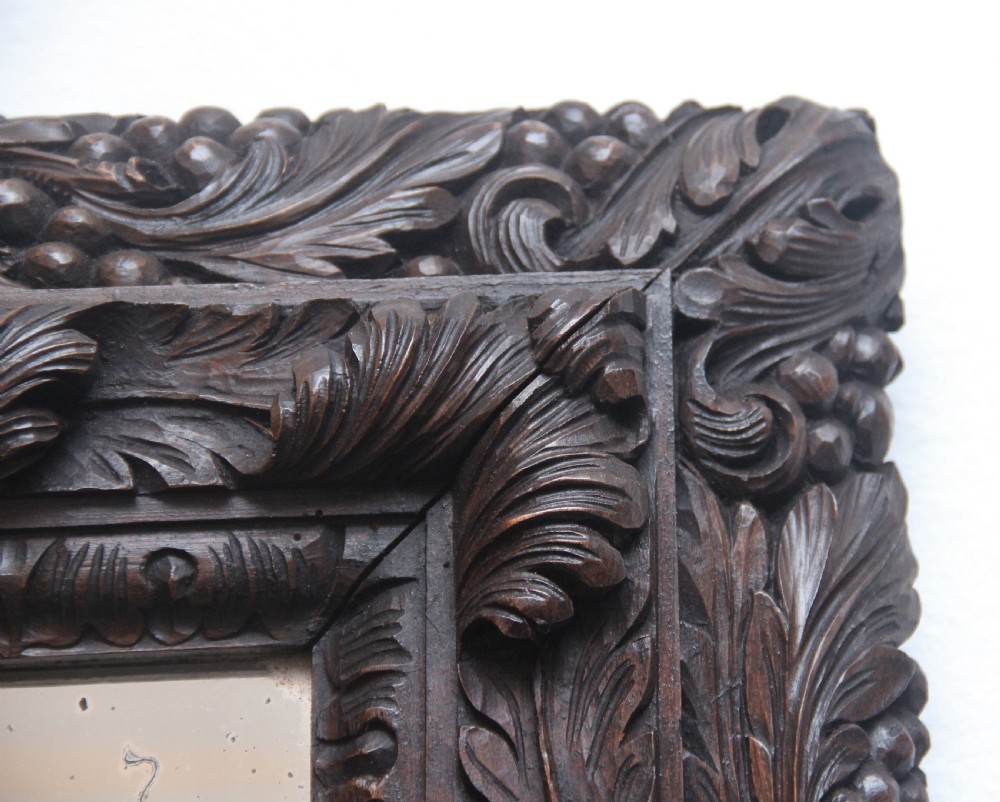 A rectangular 18th century wall mirror featuring a deeply carved dark oak frame with acanthus leaf motifs. View IV