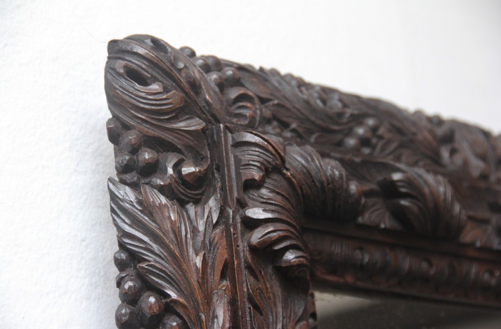A rectangular 18th century wall mirror featuring a deeply carved dark oak frame with acanthus leaf motifs. View V