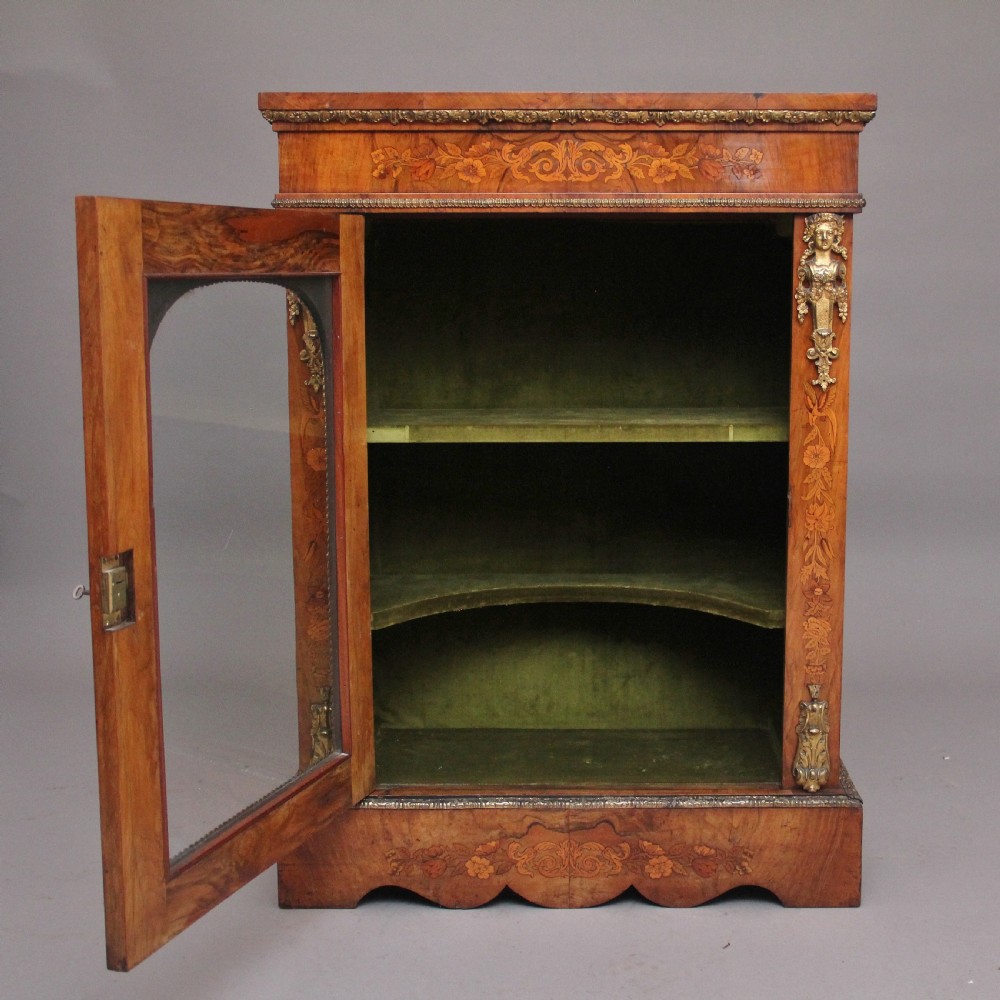A nineteenth-century walnut pier cabinet featuring intricate floral marquetry, gilt metal mounts, and a central glazed door. View II