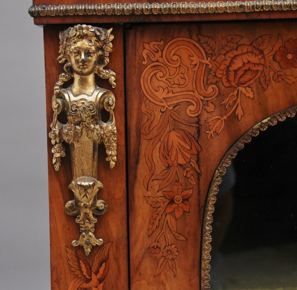A nineteenth-century walnut pier cabinet featuring intricate floral marquetry, gilt metal mounts, and a central glazed door. View IX