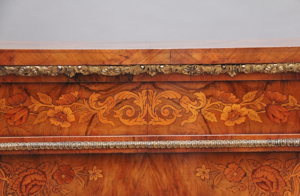 A nineteenth-century walnut pier cabinet featuring intricate floral marquetry, gilt metal mounts, and a central glazed door. View XI