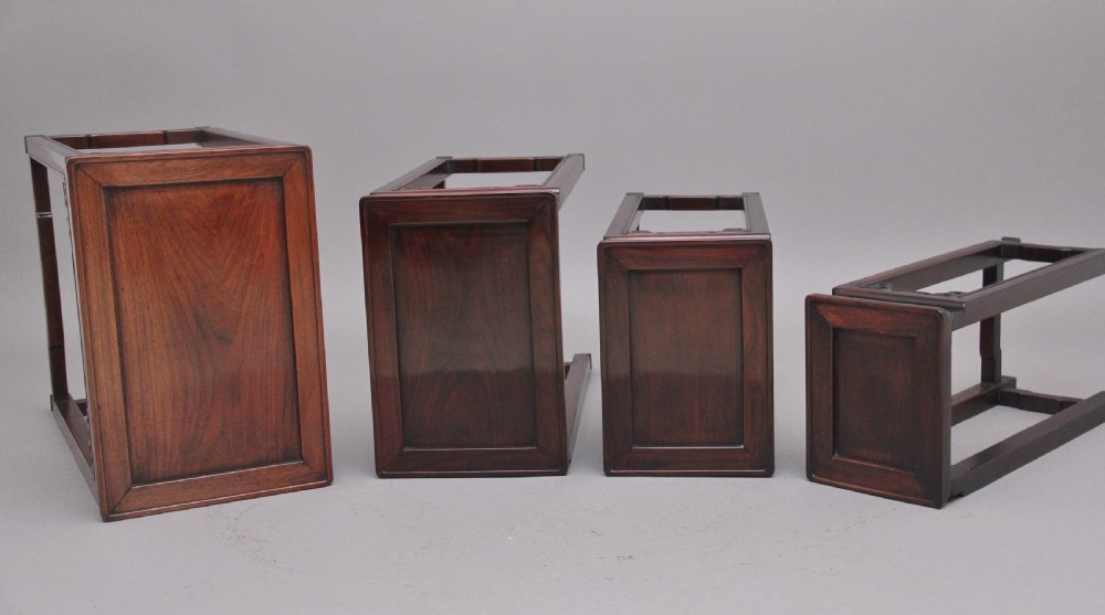 A graduating set of four dark hardwood Chinese nesting tables featuring carved corner spandrels and stepped stretchers. View IX