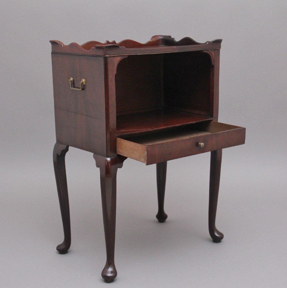 An early 20th-century Georgian-style mahogany bedside cabinet with a scalloped gallery top, open compartment, drawer, brass side handles, and cabriole legs. View II