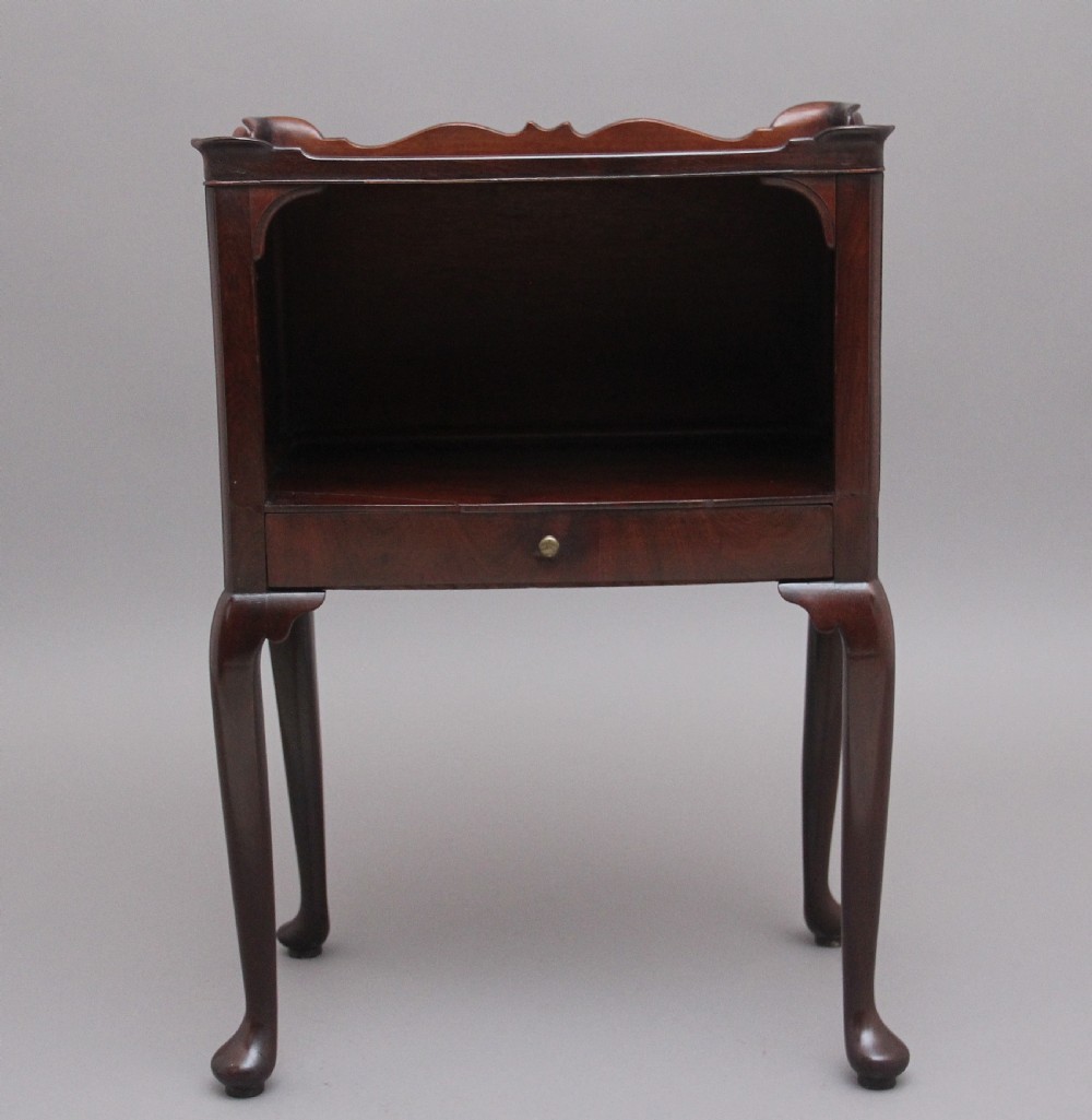 An early 20th-century Georgian-style mahogany bedside cabinet with a scalloped gallery top, open compartment, drawer, brass side handles, and cabriole legs. View III