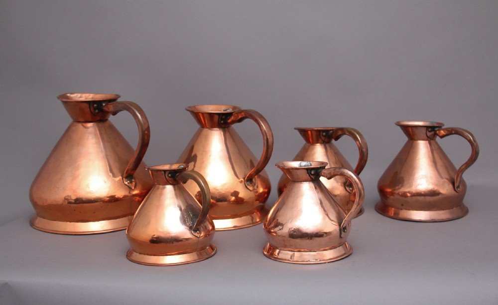 A set of six highly decorative 19th Century copper measuring jugs View II