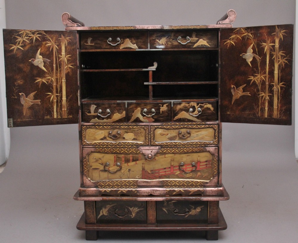 A 19th-century Japanese gilt lacquer tabletop cabinet featuring double doors with high-relief carved birds, several drawers, and decorative copper corner mounts. View III