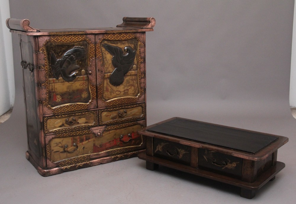 A 19th-century Japanese gilt lacquer tabletop cabinet featuring double doors with high-relief carved birds, several drawers, and decorative copper corner mounts. View VIII