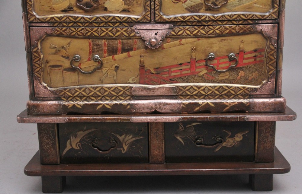 A 19th-century Japanese gilt lacquer tabletop cabinet featuring double doors with high-relief carved birds, several drawers, and decorative copper corner mounts. View XI