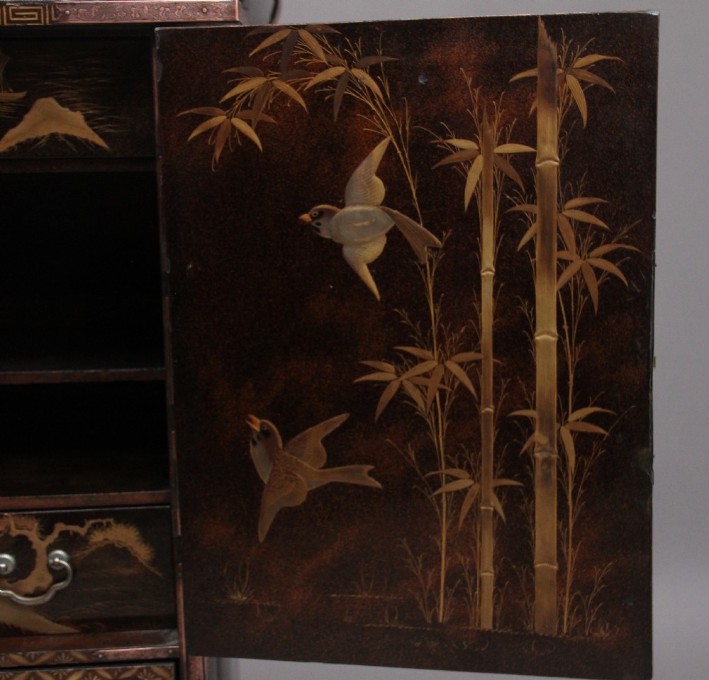 A 19th-century Japanese gilt lacquer tabletop cabinet featuring double doors with high-relief carved birds, several drawers, and decorative copper corner mounts. View XVI