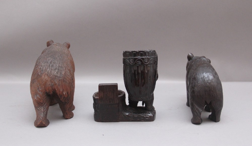 A set of three nineteenth-century hand-carved dark wood Black Forest bear figures, including two standing bears and one central desk accessory bear. View V