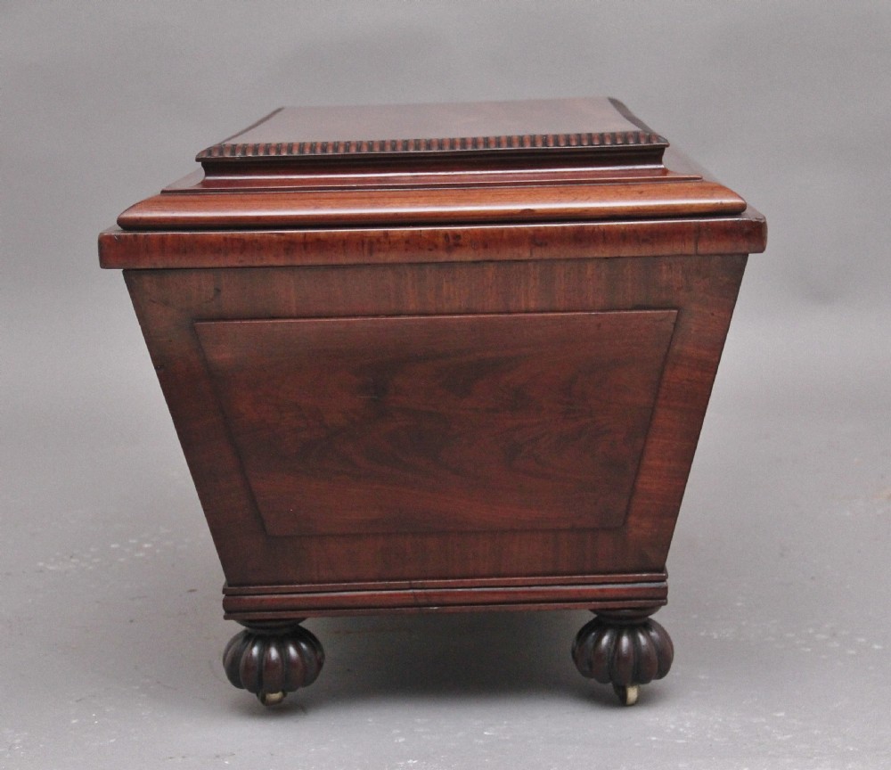 A 19th-century mahogany cellarette of sarcophagus form featuring a stepped lid, panelled sides, and carved gadrooned feet with castors. View VII