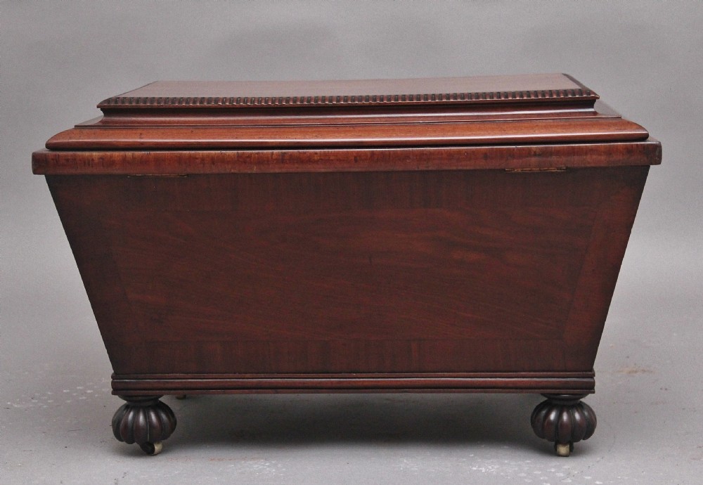A 19th-century mahogany cellarette of sarcophagus form featuring a stepped lid, panelled sides, and carved gadrooned feet with castors. View VIII