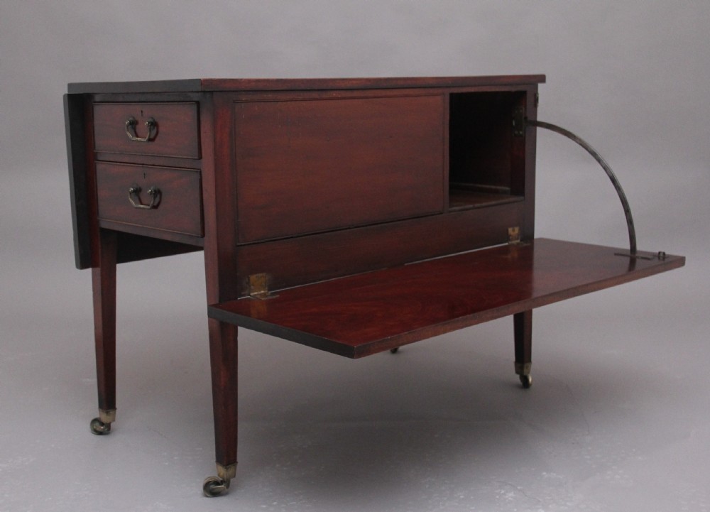 An 18th-century mahogany drop-leaf side table featuring two end drawers with brass bail handles and square tapered legs ending in brass castors. View II